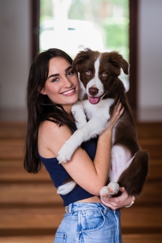 woman cuddling her border collie puppy - Australian Stock Image