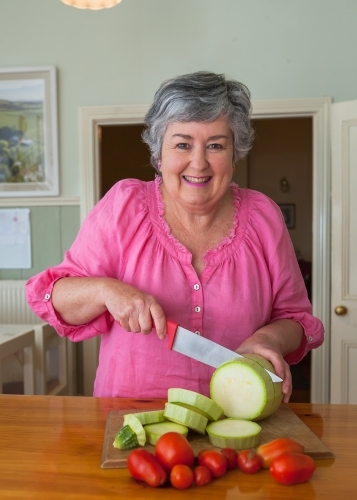 Woman cutting vegetables - Australian Stock Image