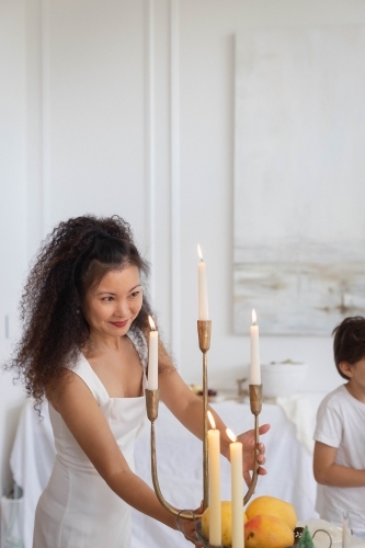 Woman decorating table with candles - Australian Stock Image
