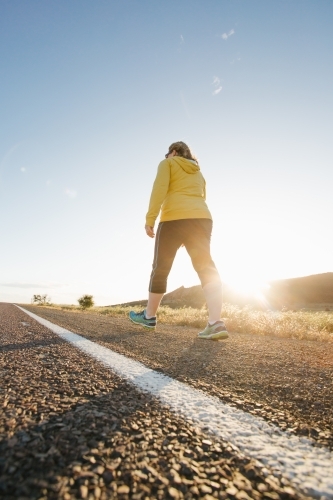 Woman doing exercise on a remote country road - Australian Stock Image