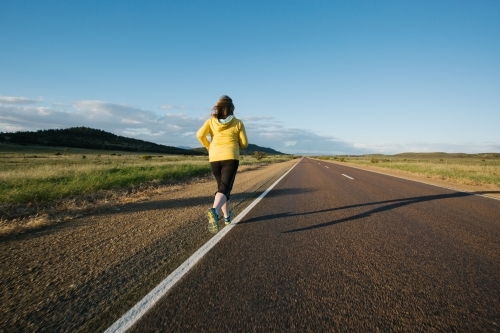 Woman doing exercise on a remote country road - Australian Stock Image