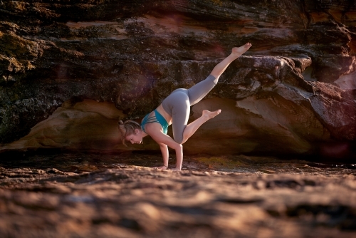 Woman doing yoga by the ocean - Australian Stock Image
