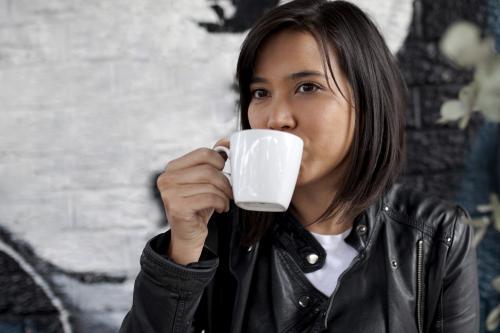Woman drinking coffee from a mug - Australian Stock Image