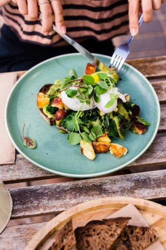 woman eating breakfast in cafe - Australian Stock Image