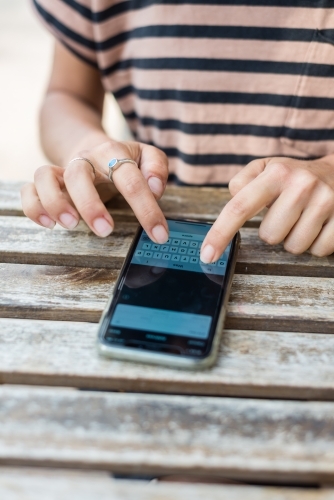 woman entering details into phone app - Australian Stock Image