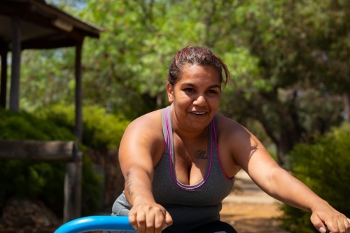 woman exercising outdoors on community fitness equipment - Australian Stock Image
