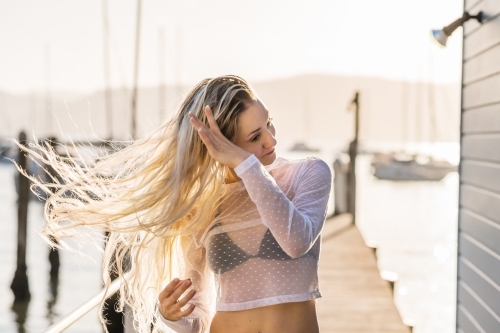 woman flipping her long blonde hair - Australian Stock Image