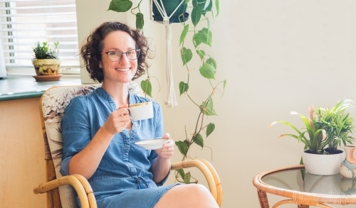 Woman having a cup of tea in her home - Australian Stock Image