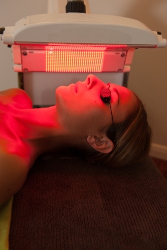 woman having beauty light therapy session, red light - Australian Stock Image