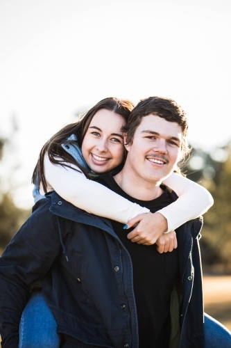 Woman having piggy back ride from boyfriend smiling - Australian Stock Image