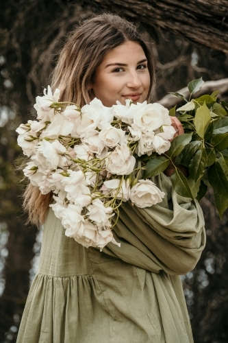 woman holding bunch of roses looking back - Australian Stock Image