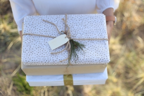 Woman holding presents with sea grass in background