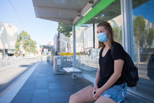 Woman in Face Mask Waits for the Tram