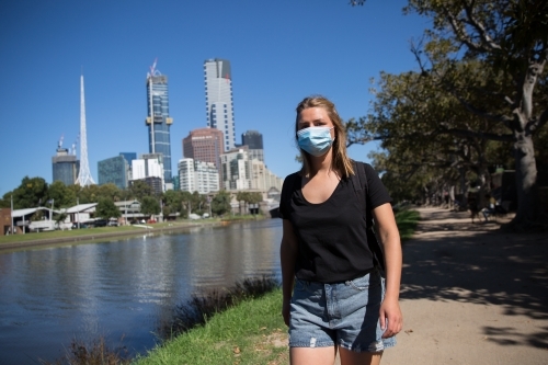 Woman in Face Mask Walking by the Yarra - Australian Stock Image