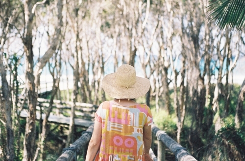 Woman in hat walks toward beach - Australian Stock Image