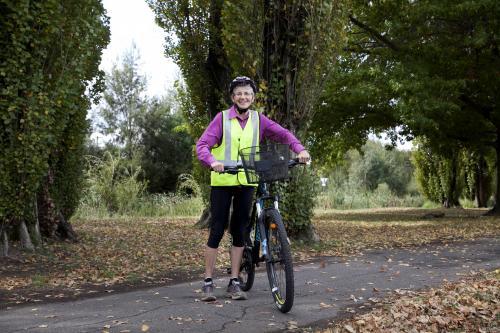 Woman in high visability vest standing with bike