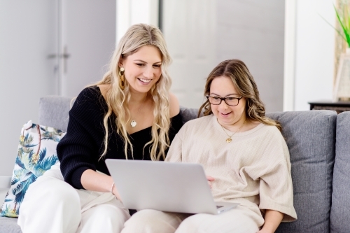 woman laughing at something on laptop - Australian Stock Image