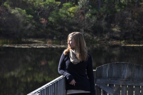 Woman leaning on fence the river - Australian Stock Image