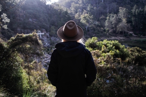 Woman looking out over Cataract Gorge wearing hat and jacket - Australian Stock Image