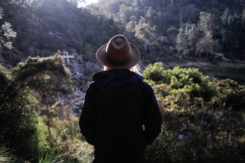 Woman looking out over Cataract Gorge wearing hat and jacket