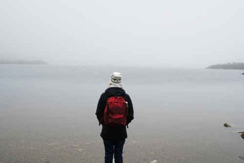 Woman looking out over Dove Lake, Tasmania - Australian Stock Image