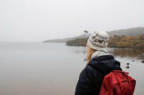 Woman looking over Dove Lake wearing beanie and backpack