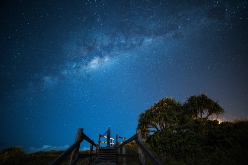 Woman looking up pointing to the Milky Way above her in the sky. - Australian Stock Image