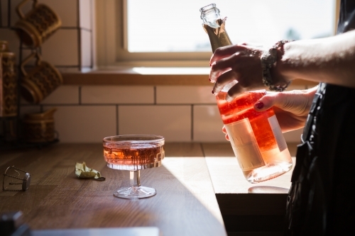 Woman pouring a glass of pink champagne cloe up