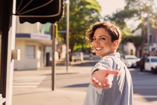 woman reaching back with hand out