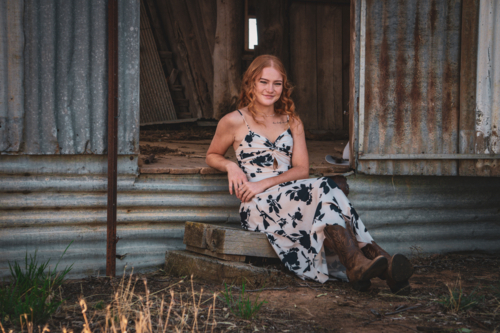 Woman sitting by a shearing shed - Australian Stock Image