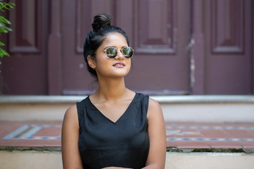 woman sitting outside front door of house - Australian Stock Image
