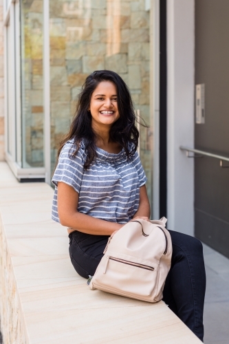 woman sitting outside modern building - Australian Stock Image