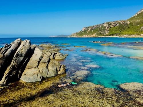 Woman snorkelling in clear lagoon in remote coastal location