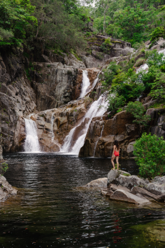 Woman standing alone at Clamshell Falls at Behana Gorge in Cairns, Queensland - Australian Stock Image