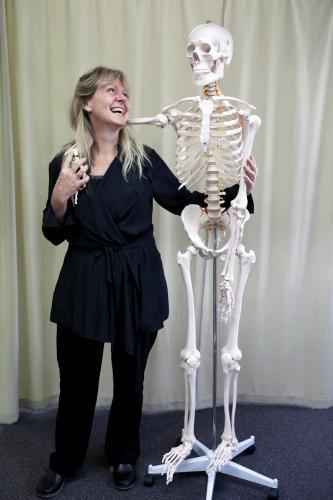 Woman standing and laughing with skeleton - Australian Stock Image