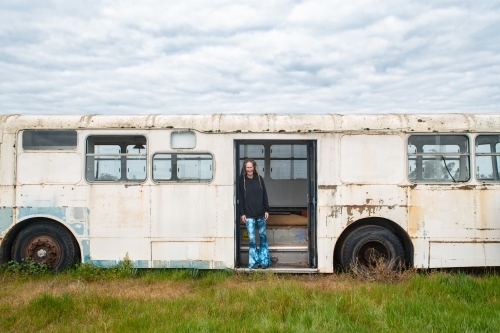 Woman standing at the exit steps on an old bus. - Australian Stock Image