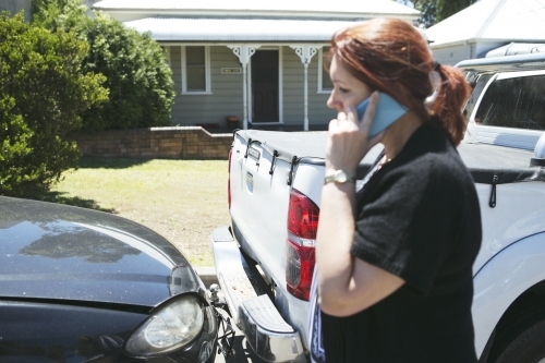 Woman standing beside car accident