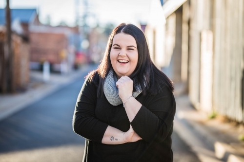 Woman standing in alley laughing - Australian Stock Image