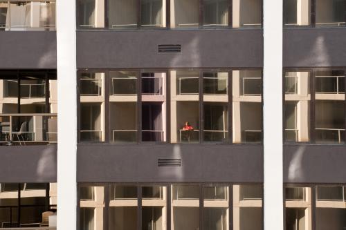 Woman standing on the balcony of a high rise apartment