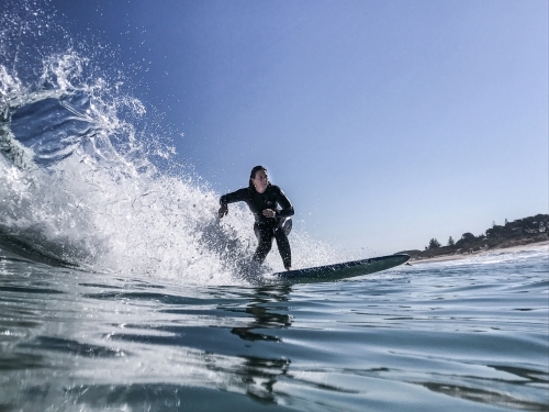 Woman surfing wave on longboard
