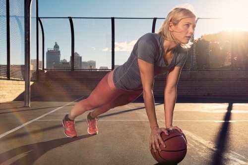 Woman training with basketball in morning light - Australian Stock Image