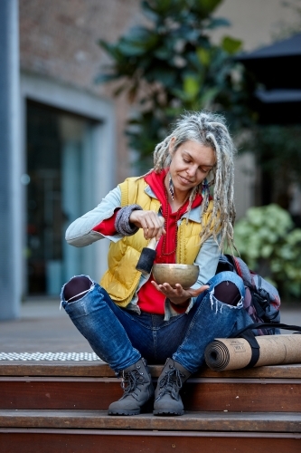 Woman using Tibetan singing bowl - Australian Stock Image
