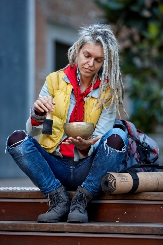 Woman using Tibetan singing bowl - Australian Stock Image