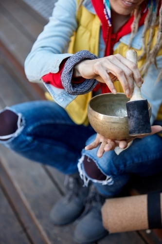Woman using Tibetan singing bowl - Australian Stock Image