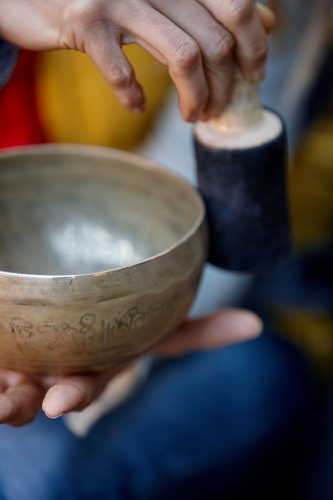 Woman using Tibetan singing bowl - Australian Stock Image