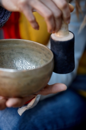 woman using Tibetan singing bowl - Australian Stock Image