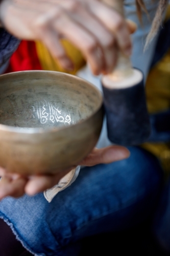 Woman using Tibetan singing bowl - Australian Stock Image