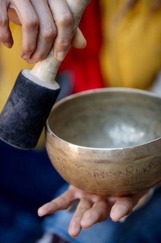 Woman using Tibetan singing bowl - Australian Stock Image