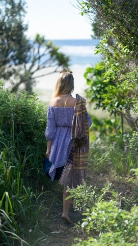 Woman walking away through beach path - Australian Stock Image