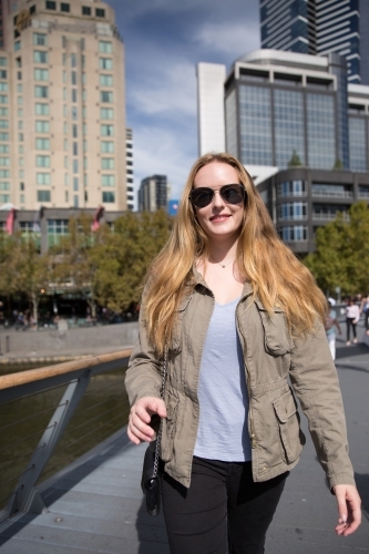 Woman walking in Melbourne city, in the Winter Sunshine - Australian Stock Image